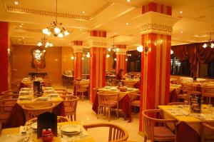 una sala da pranzo con tavoli, sedie e accessori di Hotel Mounia a Fes