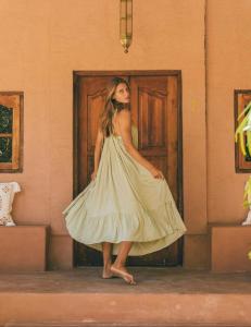 Eine Frau in einem Kleid, die vor einer Tür steht. in der Unterkunft Terra Cottages Bali in Uluwatu