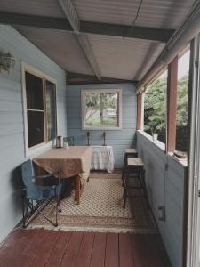 - une terrasse couverte avec une table et des chaises dans une maison dans l'établissement Camp NATURE, à Bli Bli