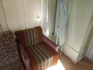 a room with a chair and a window with a curtain at Holiday Home on Liepajas Street in Aizpute