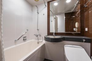 a bathroom with a sink and a toilet and a mirror at Hotel JAL City Haneda Tokyo in Tokyo