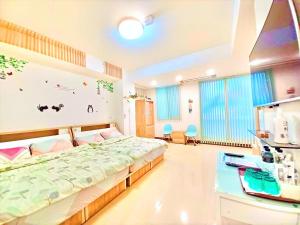 潮州鎮的住宿－屏東潮州民宿樂活藝術家，一间卧室配有一张大床和一张书桌