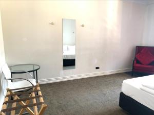a bedroom with a mirror and a chair and a bed at Fort Street Accommodation in Auckland