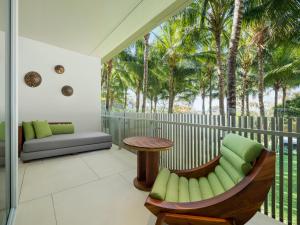 a balcony with a table and chairs and palm trees at W Bali - Seminyak in Seminyak +132 photos