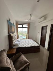 可倫坡的住宿－Fully Furnished Apartment，一间卧室配有一张床、一张沙发和一个窗口