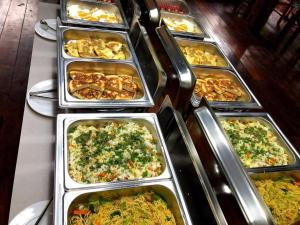 ein Buffet mit vielen Tabletts verschiedener Arten von Speisen in der Unterkunft Mahasok hotel in Luang Prabang