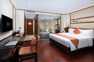 a hotel room with a bed and a desk and a bathroom at The Yun Resort QingYuan in Qingyuan