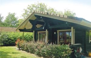een klein zwart huis met een gambrel dak bij Nice Home In Hulshorst With Wifi in Hulshorst