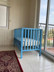 eine blaue Bank in einem Zimmer mit Fenster in der Unterkunft Home Office,Whitefield, ITPL in Bangalore