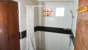 bagno con doccia e tenda doccia di La Nusa Penida Homestay a Nusa Penida