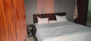 a bedroom with a bed with white sheets and pillows at SPOT ON Hotel Paradise Inn in Gorakhpur