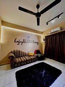 un soggiorno con un divano e un ventilatore a soffitto di Totoi Melaka a Malacca
