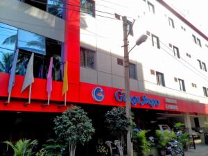 a building with flags in front of it at Ganga Sagar Hotel in Bengaluru