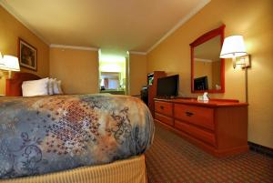 Habitación de hotel con cama y tocador con espejo en Americas Best Value Inn Killeen Ft Hood, en Killeen