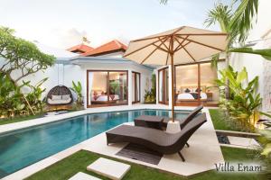 a pool with a chair and an umbrella next to a house at Villa Mia Seminyak - Boutique Villas in Seminyak