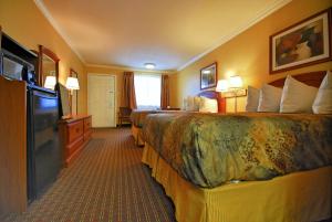 Americas Best Value Inn Killeen Ft Hood في كيلين: غرفة فندقية بسريرين وتلفزيون بشاشة مسطحة