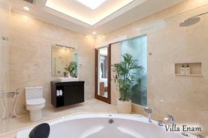 a large bathroom with a tub and a toilet at Villa Mia Seminyak - Boutique Villas in Seminyak