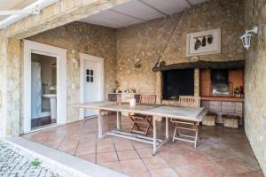 a kitchen with a table and a stone wall at Villa very quiet, fantastic views, ideal for families, fun and relaxation. in São João da Ribeira