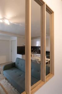 a mirror with a blue couch in a living room at Cabana & Hypercentre Cosy in Roanne
