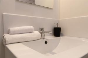 a white bathroom sink with two towels and a mirror at Cabana & Hypercentre Cosy in Roanne