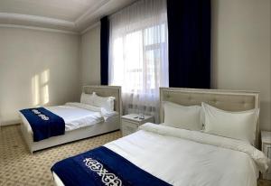 Habitación de hotel con 2 camas y ventana en Sultan Jalal-Abad en Jalal-Abad