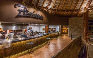 a restaurant with a kitchen with a counter and stools at The Club at Hacienda del Mar in Cabo San Lucas