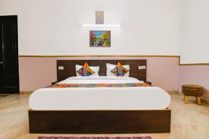 een slaapkamer met een groot wit bed met kussens bij FabHotel Water Vibe in Gurgaon