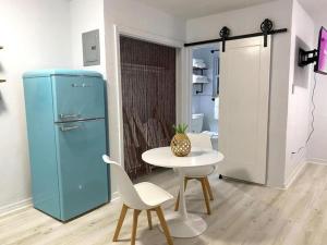 デイトナビーチにあるPineapple Shores Retro Inn 4のテーブルと青い冷蔵庫が備わる客室です。