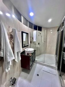 y baño con bañera, lavamanos y ducha. en Hotel Ingenio Reina Isabel, en Cali