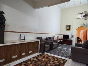 uma sala de espera com sofás e uma televisão em Redzuan Homestay (Muslim Friendly) em Muar