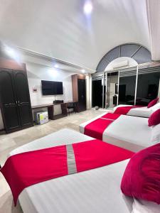 a bedroom with four beds and a flat screen tv at Hotel Ingenio Reina Isabel in Cali