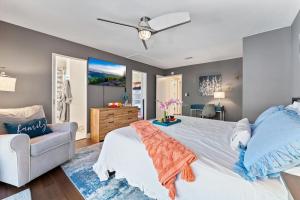 a bedroom with a large white bed and a couch at Seabreeze-Modern Home w Outdoor Living&Near Beach in Huntington Beach