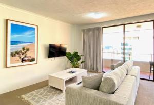 a living room with a couch and a tv at The Astor Apartments in Brisbane