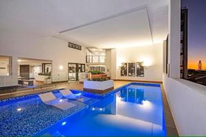 uma grande piscina num quarto com casa em Upmarket Comfortable Large 2 Bed 2 Bath, OCEAN VIEWS, 250m to BUDDINA BEACH! em Buddina