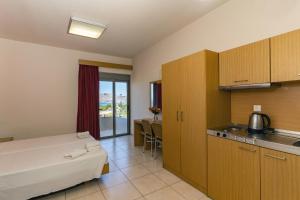 a hotel room with a bed and a kitchen at Lia Studios in Pefki Rhodes