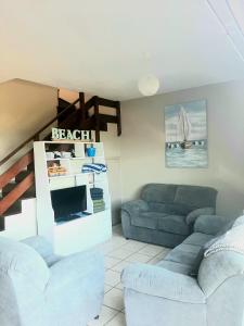 a living room with two couches and a tv at La Corsica Beach House Breakaway in Margate