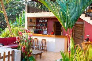a restaurant with a bar in a garden with plants at Villa Anakao Abidjan in Abidjan