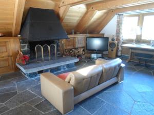 sala de estar con sofá y chimenea en Chalet Atelier en Davos