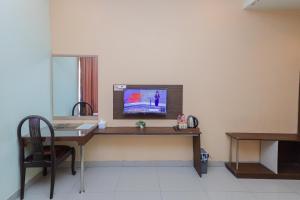 an office with a desk with a computer on the wall at RedDoorz near Alun Alun Madiun in Madiun