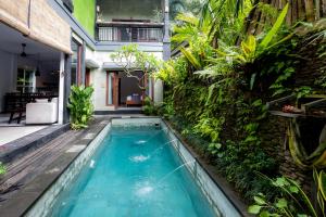 a pool in the backyard of a house with plants at Villa Kubu Arya by Supala in Ubud