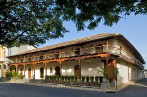 格拉纳达Hotel Plaza Colon - Granada Nicaragua的一座带茅草屋顶的古老建筑