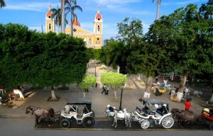 
motorcycles are parked on the side of the road at Hotel Plaza Colon - Granada Nicaragua in Granada
