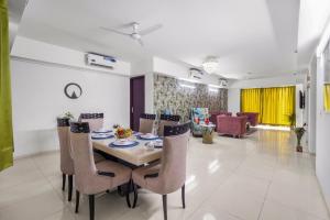 a dining room and living room with a table and chairs at Homlee-Super Luxury 4 BHK Apartment nr NOIDA EXPO in Noida