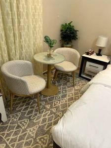 1 dormitorio con mesa, 2 sillas y 1 cama en غرفة صغيرة ساحرة en Riad