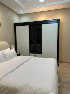 a bedroom with a white bed and a large window at غرفة صغيرة ساحرة in Riyadh