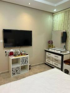 a bedroom with a flat screen tv on the wall at غرفة صغيرة ساحرة in Riyadh