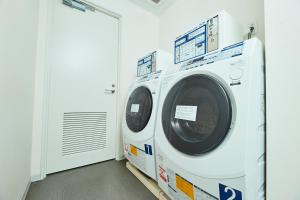 eine Waschmaschine in einer Waschküche mit Tür in der Unterkunft RIHGA Place Kyoto Shijo Karasuma in Kyoto