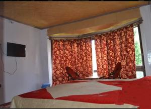 a bedroom with a bed and two chairs and a window at Grand Heritage Resort in Pahalgām