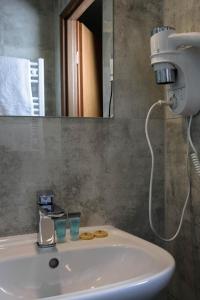 y baño con lavabo blanco y espejo. en Hotel George, en Nadarzyn