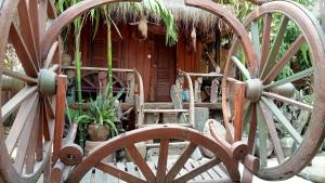 a house with a thatched roof with two wooden wagon wheels at Kakrona Pouk Homestay in Siem Reap